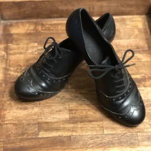 Black wingtip style lace up booties / heels.